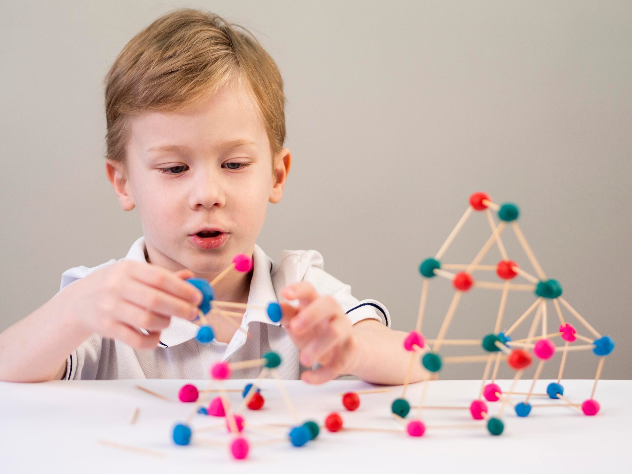 boy playing with colorful atoms game home 1 scaled