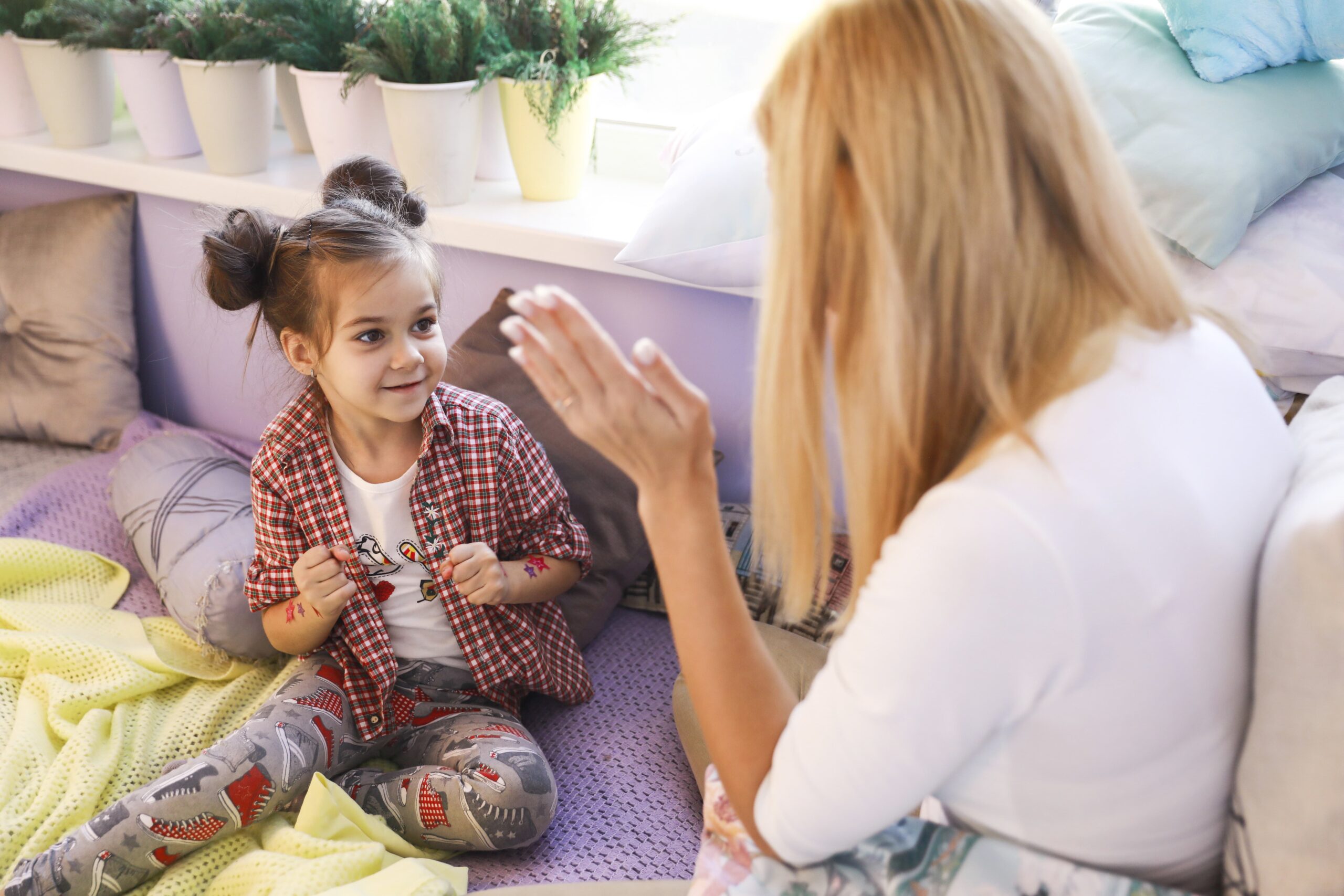 young girl is playing with mother near window 1 scaled