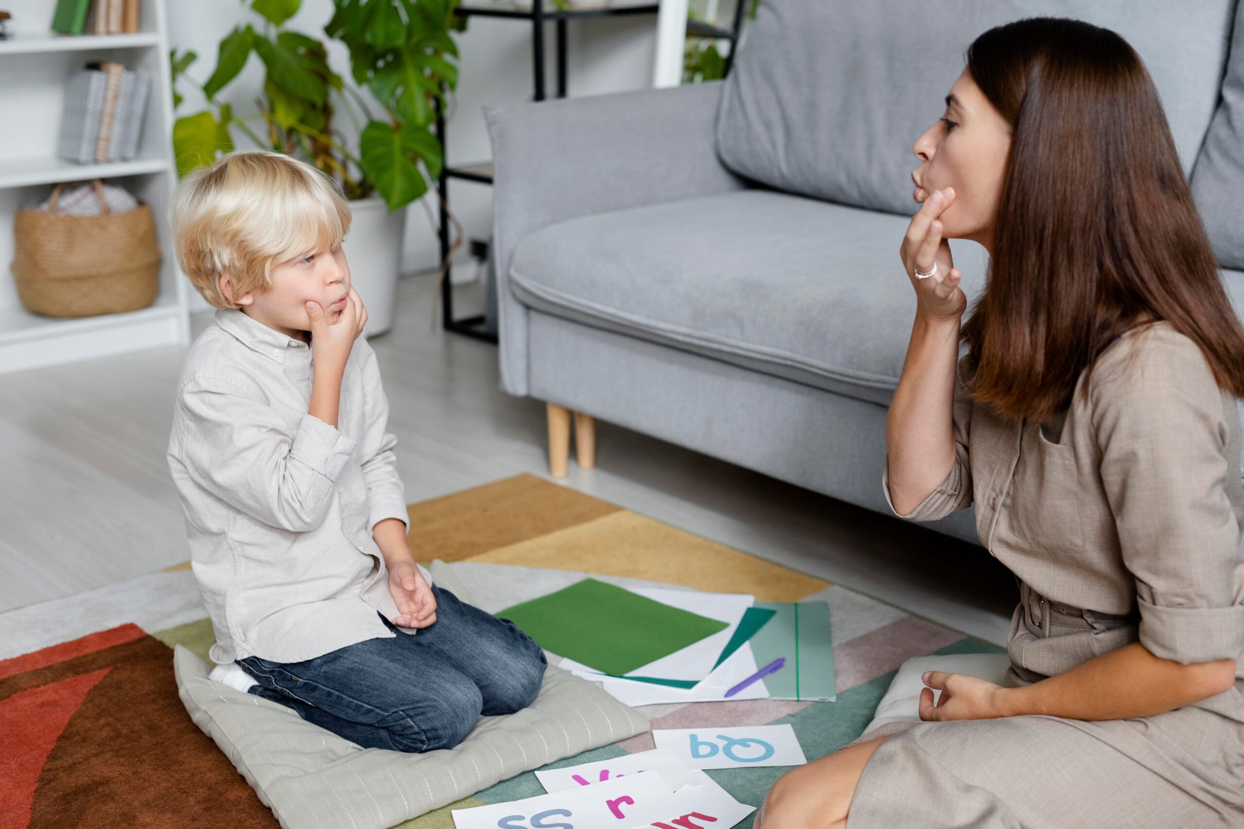 young woman doing speech therapy with little boy 1 1 scaled